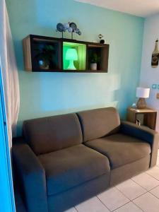 brązowa kanapa w salonie z zielonym światłem w obiekcie studio proche plages w mieście Les Trois-Îlets
