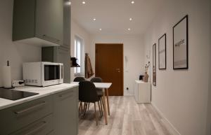 a kitchen with a microwave and a table with chairs at CASA BIA in Bergamo