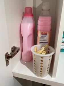 a shelf with two pink bottles and a basket of food at LAR DE SEFA in Redondela