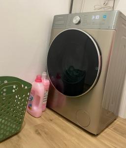 a washing machine sitting on the floor next to a laundry basket at LAR DE SEFA in Redondela