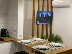 a kitchen with a table with glasses and a tv at LAR DE SEFA in Redondela