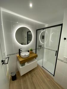 a bathroom with a sink and a shower with a mirror at LAR DE SEFA in Redondela