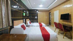 ein Hotelzimmer mit 2 Betten und einem TV in der Unterkunft RedDoorz at Winter Hotel Araneta in Manila