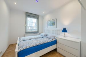 a small bedroom with a bed and a window at Apartament Sopocki in Sopot