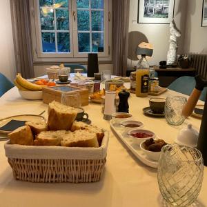 a table with a basket of bread on it at Ainsi de Suites - Chambres & table d'hôtes - Spa & massages in Reugny