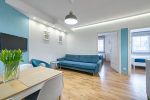 a living room with a blue couch and a table at Apartament Sopocki in Sopot