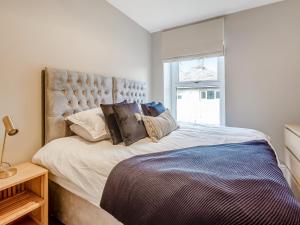 a bedroom with a large bed with a large window at Townhouse in Llandudno