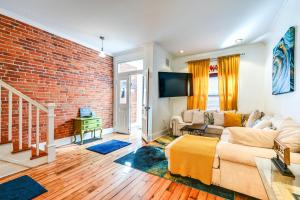 a living room with a brick wall at Bright Harrisburg Retreat about 14 Mi to Hersheypark! in Harrisburg