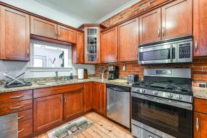 a kitchen with wooden cabinets and stainless steel appliances at Bright Harrisburg Retreat about 14 Mi to Hersheypark! in Harrisburg