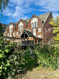 un grand bâtiment en briques avec un pont devant lui dans l'établissement Domaine de la Forêt d'Orient, Logis Hôtel, Restaurant, Spa et Golf, à Rouilly-Sacey