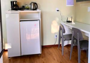 eine Küche mit einer weißen Theke sowie einem Tisch und Stühlen in der Unterkunft Suíte Luxo Contêiner in Boa Vista + 6 Fotos