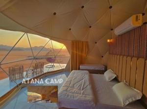 a bedroom with a bed and a view of the desert at RUM ATANA lUXURY CAMP in Wadi Rum
