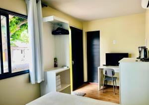 ein Zimmer mit einem Bett und einem Schreibtisch mit einem Computer in der Unterkunft Suíte Luxo Contêiner in Boa Vista