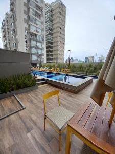 a patio with a bench and a swimming pool at Novo, lazer completo e 3 quadras da Av. Paulista. in São Paulo