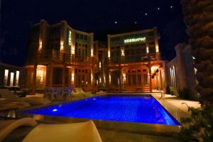 NEOM DAHAB - - - - - - - - - - - Your new hotel in Dahab with private beach في دهب: مسبح امام مبنى في الليل