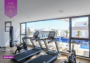 - une salle de sport avec des appareils de cardio-training et une vue sur la piscine dans l'établissement JourneyJoy II Luxury Apartment with Pool & Gym, à Sidi Daoud