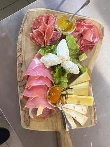 una tabla de cortar con carne y queso sobre una mesa en Agriturismo Podere Farnesiana en Tarquinia