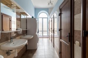 uma casa de banho com 2 lavatórios e uma janela em Soborniy Hostel em Lviv