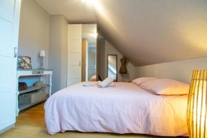 1 dormitorio con 1 cama grande con sábanas rosas en Gîte de la tour des Fripons. en Kientzheim