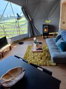 a living room with a couch and a fireplace at Little River Glamping in Ballymoney +127 photos