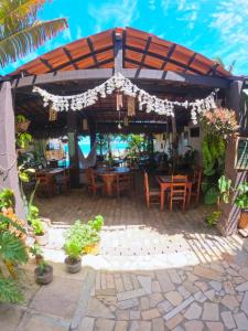 un patio con mesas y sillas bajo una pérgola en Coco-Knots Kite - Ilha do Guajiru en Itarema