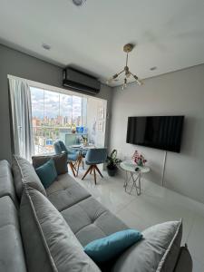 a living room with a couch and a flat screen tv at Novo, lazer completo e 3 quadras da Av. Paulista. in Sao Paulo