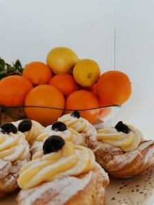 a plate of pastries with oranges and a bowl of fruit at Carpe Diem B&B e Case Vacanza in Monopoli