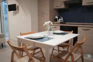 カターニアにあるLi Cuti Homeの白いテーブルと椅子、花瓶
