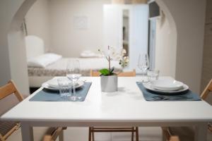- une table à manger blanche avec des verres et des assiettes dans l'établissement Li Cuti Home, à Catane