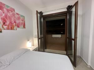 a bedroom with a bed and a sliding glass door at Ciclamino Appartamento Roma in Infernetto