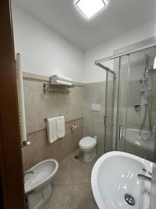 a bathroom with a sink and a toilet and a shower at Ciclamino Appartamento Roma in Infernetto