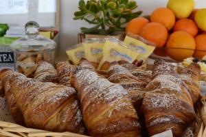 - un panier de viennoiseries sur une table avec des oranges dans l'établissement Carpe Diem B&B e Case Vacanza, à Monopoli