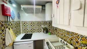 uma pequena cozinha com azulejos amarelos e brancos na parede em Cascais Dream Stay III - Pool em Cascais