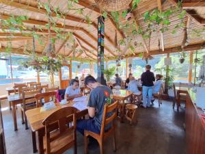 um grupo de pessoas sentadas em mesas em um restaurante em Hostal Chimenea em Baños