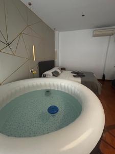 bañera en una habitación con cama en LM APARTAMENTOS PUENTEZUELAS, en Granada