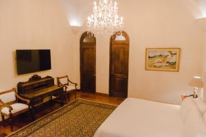 a bedroom with a bed and a chandelier at Hacienda Los Arcangeles in San Miguel de Allende