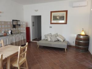 sala de estar con sofá y mesa en Poggio la Luna la casa nel vigneto en Montemerano