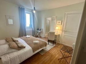 a bedroom with a bed and a desk and a window at La Douceur - 4 personnes - BCLA in Le Mans