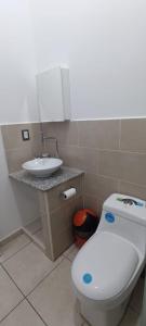 ein Badezimmer mit einem weißen WC und einem Waschbecken in der Unterkunft ParadaHome in San Ramón