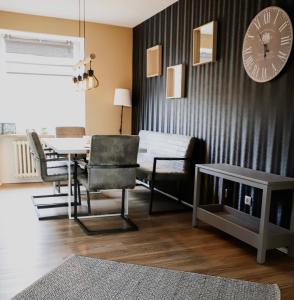 sala de estar con mesa y reloj en la pared en Angela Apartments, en Würzburg