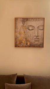 uma pintura de uma cabeça numa parede acima de um sofá em City view apartments 1 em Serres