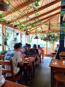 un grupo de personas sentadas en mesas en un restaurante en Hostal Chimenea en Baños