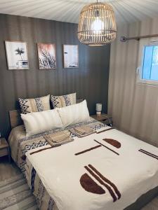 a bedroom with a large bed with a chandelier at 2P au coeur des montagnes avec piscine chauffée in Puget-Théniers