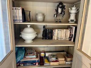 a book shelf with books and other items on it at Maison de centre-village "Au bord de l'Ô" - Jardin - Parking in Cormeilles