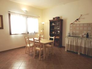 cocina con mesa y sillas en una habitación en Poggio la Luna la casa nel vigneto en Montemerano