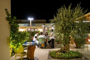 a group of people sitting at a table at night at Hotel Barbagia in Dorgali