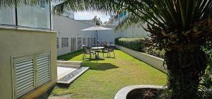 a backyard with a table and chairs and a palm tree at Option Full Service Residence in Rio de Janeiro