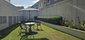 a table and chairs with an umbrella on a patio at Option Full Service Residence in Rio de Janeiro