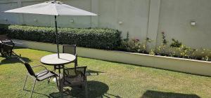 a table and chairs with an umbrella in a yard at Option Full Service Residence in Rio de Janeiro