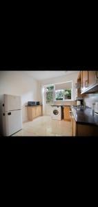 a kitchen with white appliances and a window at Neasdon's Guest Nest- 7 mins drive to Wembley Stadium in London